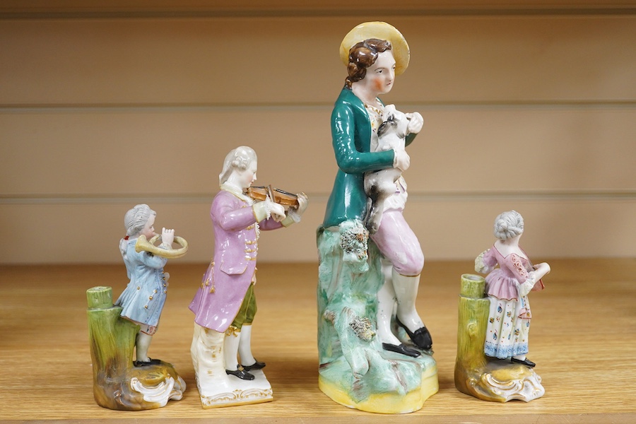 A mid 19th century Staffordshire figure wearing a green jacket, a Berlin KPM figure of a violinist and two coloured biscuit musicians, tallest 23cm. Condition - fair to good